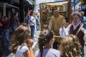 ação bibliosesc em cotia, com dois atores caracterizados falando ao público num palco itinerante