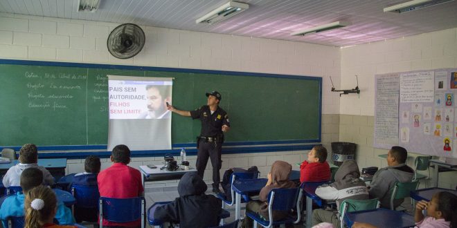 guarda civil de cotia dando palestra a crianças em sala de aula