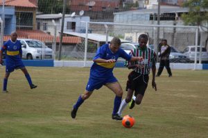 dois times masculinos disputando uma partida de futebol em Carapicuíba
