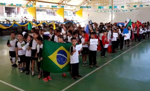 alunos da escola municipal Nai Molina, de Carapicuíba, desfilam em quadrapoliesportiva, divididos em grupos que representam os países participantes da Copa do Mundo