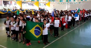 alunos da escola municipal Nai Molina, de Carapicuíba, desfilam em quadrapoliesportiva, divididos em grupos que representam os países participantes da Copa do Mundo