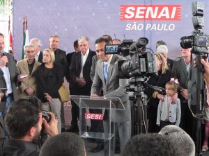 Almir Rodrigues assina o Programa Atleta do Futurndoo na tribuna do cerimonial de inauguração do SENAI Cotia