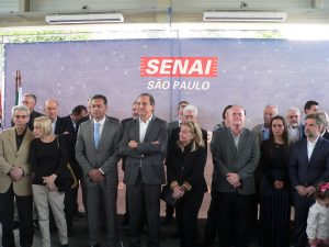 Pessoas alinhadas no palco do cerimonial de inauguração do SENAI Cotia, entre elas o presidente da Fiesp, Ciesp, Sesi-SP e SENAI-SP Paulo Skaf, vice-prefeito de Cotia Almir Rodrigues e o prefeito de Vargem Grande Paulista Josué Ramos