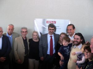 Paulo Skaf e a família Lerner posam para foto diante da placa de inauguração do SENAI Cotia