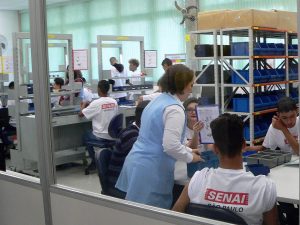 Alunos trabalhando em máquinas dentro do novo SENAI CotiaUma professora dando aula a um pequeno grupo de alunos no novo SENAI Cotia
