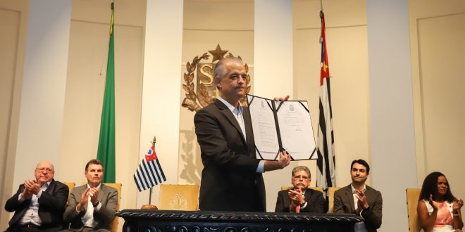 O governador do Estado de São Paulo, Márcio França, exibe documento de assinatura de convênios com municípios paulista no Palácio dos Bandeirantes