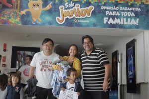 a diretoria do jornal Granja News posa para foto com família convidada diante da entrada para a Sala junior da Cinépolis do Iguatemi Alphaville