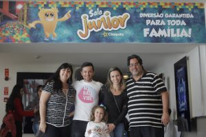 a diretoria do jornal Granja News posa para foto com família convidada diante da entrada para a Sala junior da Cinépolis do Iguatemi Alphaville
