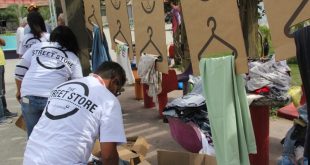 colaboradores da Fundação Alphaville montam araras de roupas durante a The Street Store