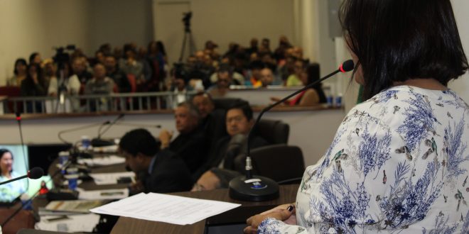 vereadora Nanda Costa discursa durante sessão na câmara de Carapicuíba, com outros vereadores no segundo plano e o público ao fundo