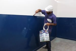 homem pintando uma parede de uma escola municipal de Carapicuíba