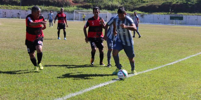 jogadores do Renegados (de cinza) e do Rubro Negro (de preto e vermelho) disputam partida de futebol