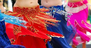 detalhe da cintura e das barrigas de quatro mulheres fazendo dança do ventre