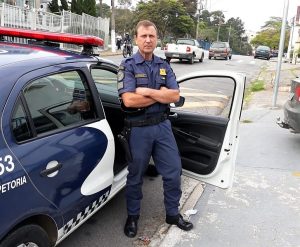 o guarda Russo de Cotia posa para foto ao lado de uma viatura da Guarda civil