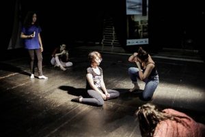 participantes fotografando uma pessoa sentada no chão