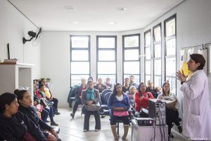 palestrante fala a um grupo de dezenas de participantes