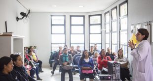 palestrante fala a um grupo de dezenas de participantes