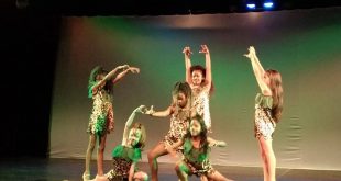 cena de espetáculo de teatro em Carapicuíba, com sete garotas se apresentando