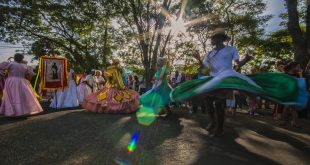pessoas dançando com estandartes e roupas típicas