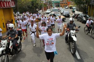 atletas correm com o fogo simbólico em mãos