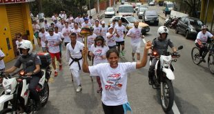 atletas correm com o fogo simbólico em mãos