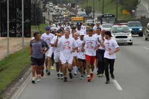 atletas correm com o fogo simbólico em mãos
