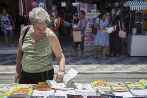 idosa folheando livrona feira do livro de cotia