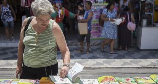 idosa folheando livrona feira do livro de cotia