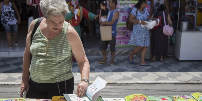 idosa folheando livrona feira do livro de cotia