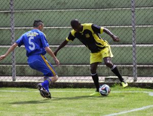 dois jogadores disputam uma bola em partida de futebol em Embu das Artes