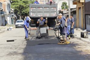 homens trabalhando em tapa-buraco em rua de carapicuíba