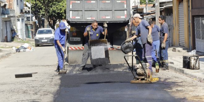 homens trabalhando em tapa-buraco em rua de carapicuíba