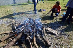 uma criança queimando pinh]pinhão em uma fogueira