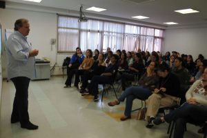 Georges Schnyder profere palestra a dezenas de pessoas em um auditório