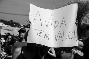 manifestantes segurando cartaz escrito 'a vida tem valor'