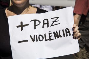 manifestante segurando cartaz escrito '+paz -violência'