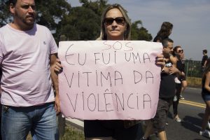 manifestante no viaduto william ortiz exibe faixa escrito 'sos eu fui uma vítima da violência'