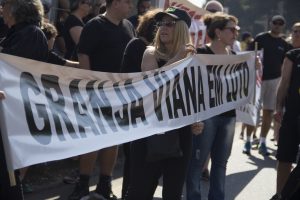 manifestantes caminhando com uma faixa escrito 'Granja Viana em luto'
