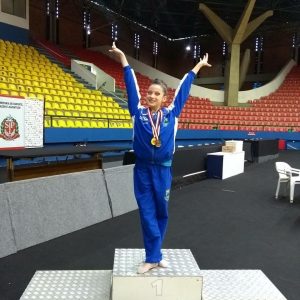 ginasta posa no primeiro lugar do pódio