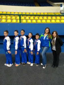 ginastas e treinadoras posam para a câmera