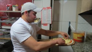 pizzaiolo prepara pizza na Pizza Estrela da Granja