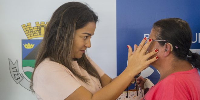 mara franco coloca óculos no rosto de uma senhora