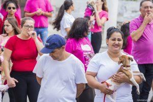 mulheres caminhando; algumas seguram cachorros