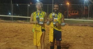 Gabriela e Marcos, a dupla campeã do 1º Torneio Misto de Vôlei de areia noturno, posa com medalhas