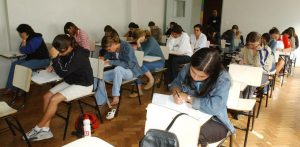 estudantes numa sala de aula prestando um exame de ENEM