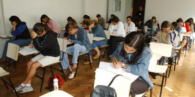 estudantes numa sala de aula prestando um exame de ENEM