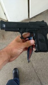 Réplica arma de fogo sendo segurada pela mão de um guarda civil