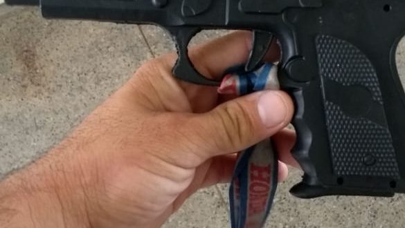 Réplica arma de fogo sendo segurada pela mão de um guarda civil