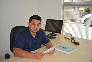 vereador rafael tanzi posa para foto sentado na mesa de seu gabinete