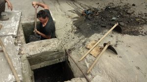 homens limpando boca de lobo na Rua Ciro Monteiro